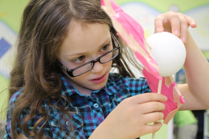 57955765_2641681272724867_5494171058950897664_o A girl focuses on building a project at a space camp.