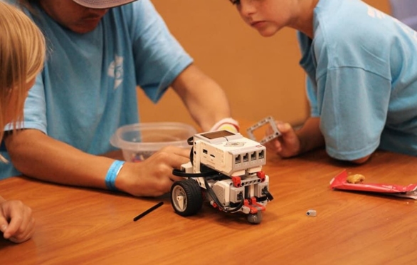robot Three boys work on a robot at a STEM summer camp